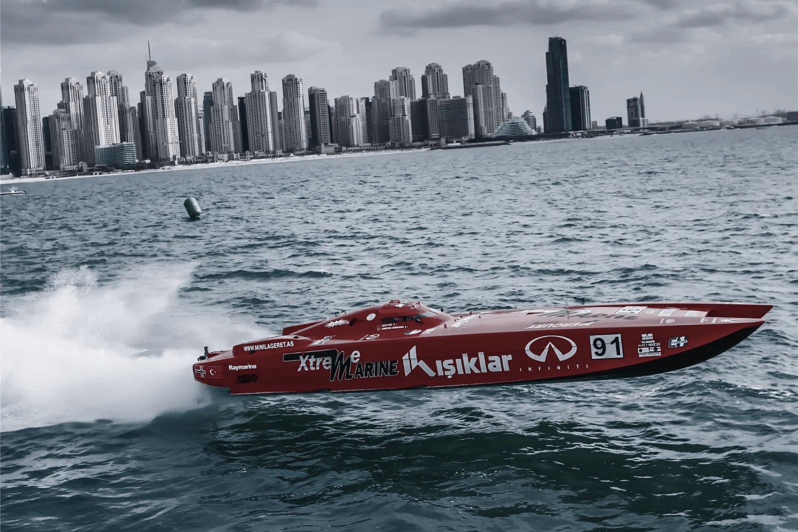 Red offshore powerboat racing against the Dubai skyline