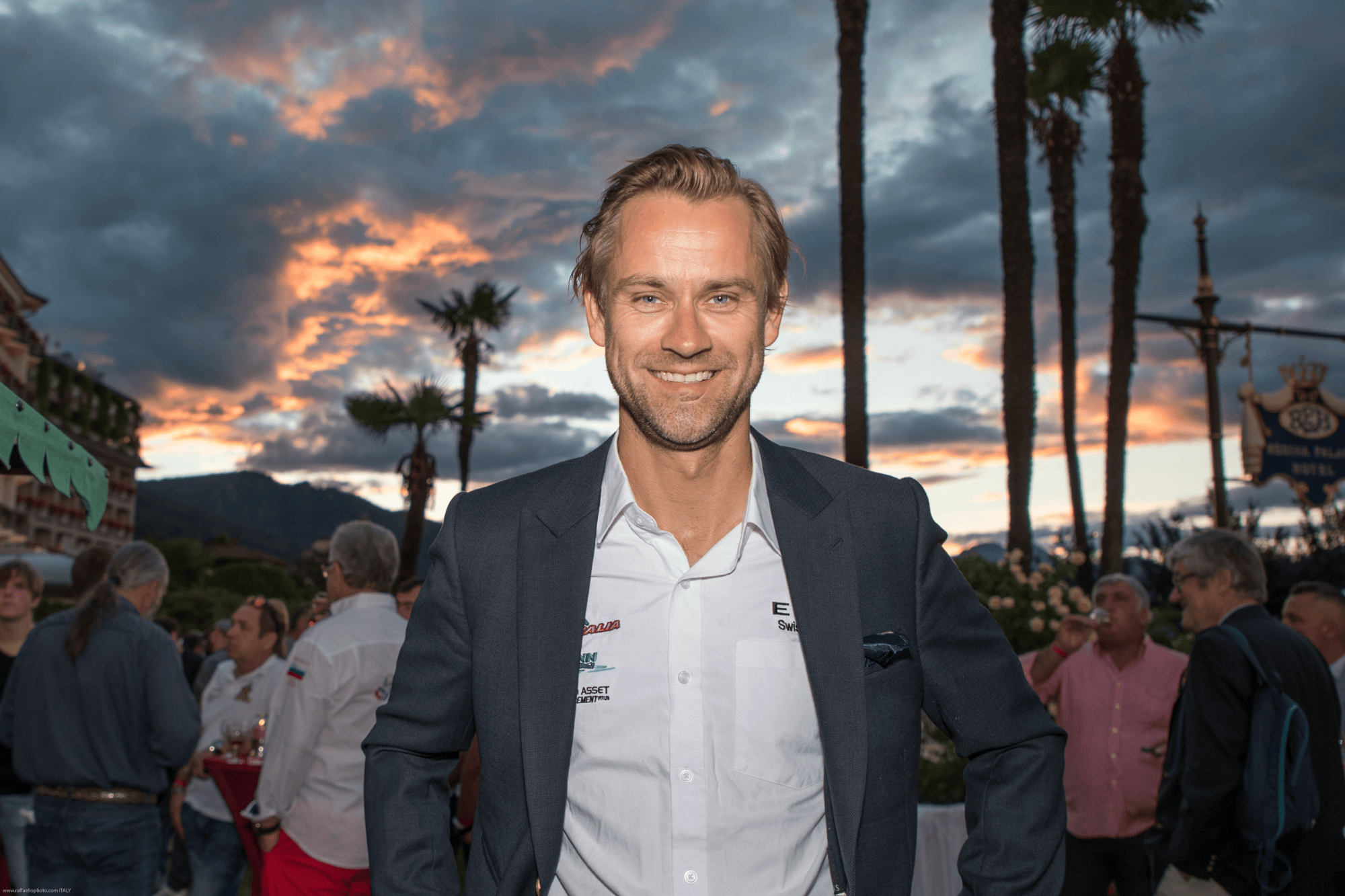 Man in a suit at sunset among palm trees