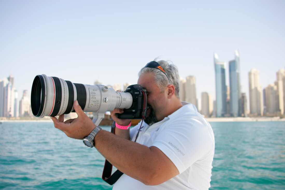 Raffaello Bastiani photographing with a telephoto lens by the water