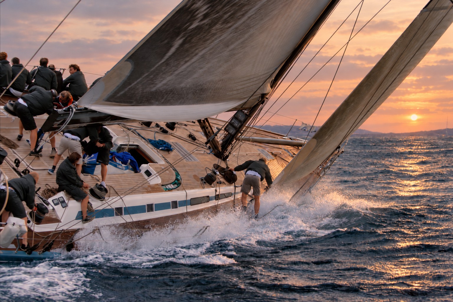 Sailing crew racing at sunset